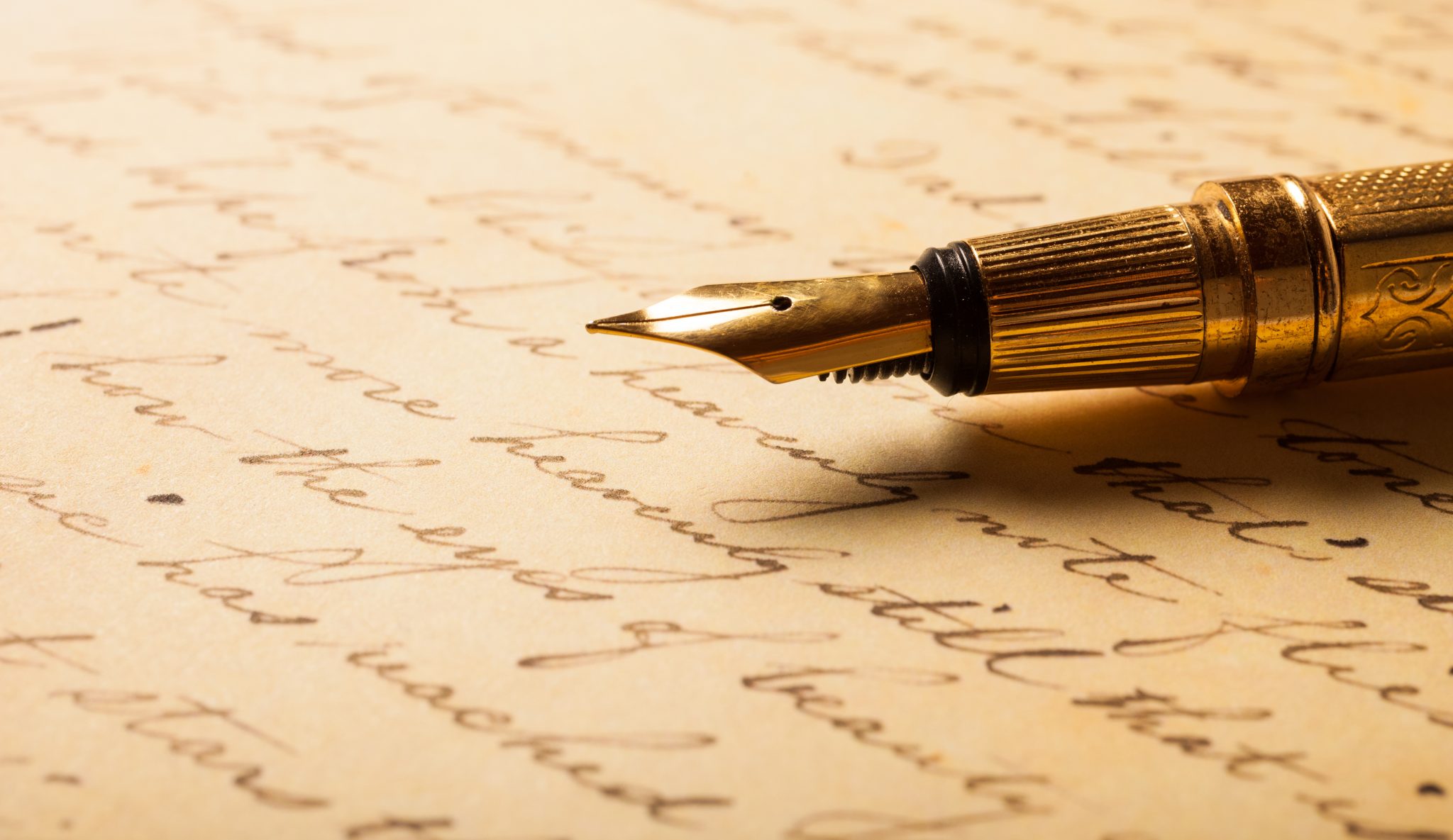 Plume dorée posée sur un manuscrit